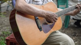 Man playing acoustic guitar outdoors - Powered by Shutterstock - Get 15% off with code: PIKWIZARD15