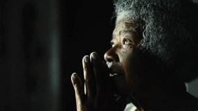 Religious Senior African American woman closing eyes in Prayer by window, close-up profile face of an elderly black lady with gray hair in deep meditation - Powered by Shutterstock - Get 15% off with code: PIKWIZARD15