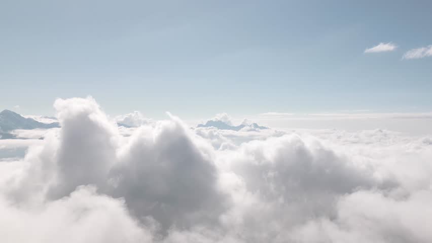 Aerial zoom in view Flying over clouds timelapse with daytime sun. Flying through moving clouds with beautiful highlights. Air travel. Ideal for cinema, background