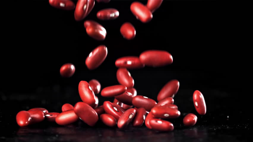 Falling red beans on a black background. Filmed on a high-speed camera at 1000 fps. High quality FullHD footage