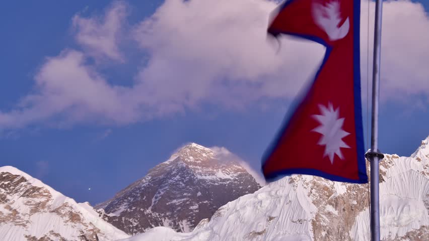 Waving nepalese flag. Mount Everest peak from Khumbu valley, Solukhumbu, Sagarmatha national park, Nepal. Trekking to EBC.Season closure concept.Changing weather conditions concept
