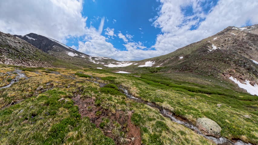 Person Walks Toward Flowing Alpine Stream In Rocky Mountain National Park