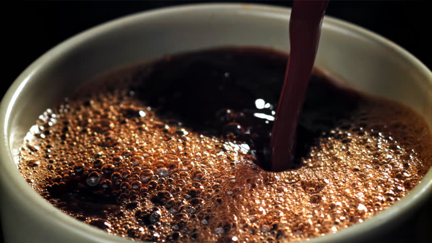 Black coffee pours into a cup. Filmed on a high-speed camera at 1000 fps. High quality FullHD footage