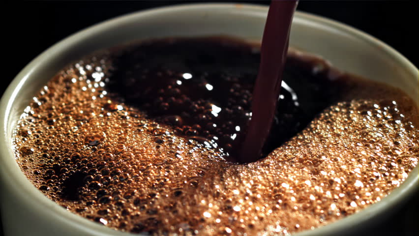 Black coffee pours into a cup. Filmed on a high-speed camera at 1000 fps. High quality FullHD footage