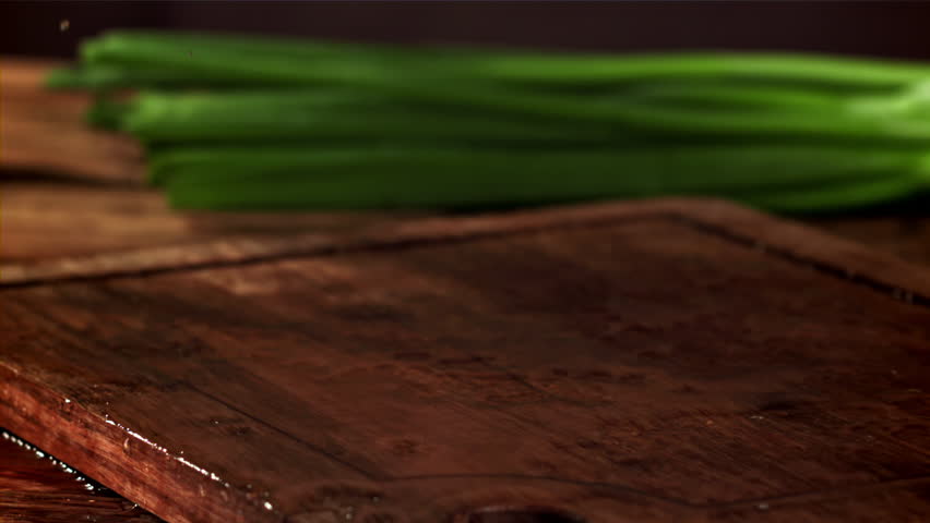Green onions fall on the table. Filmed on a high-speed camera at 1000 fps. High quality FullHD footage
