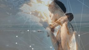 Couple walking arm-in-arm on beach, featuring technology networking using glowing digital globe. Romance, connection, digital, technology, landscape, outdoor, harmony - Powered by Shutterstock - Get 15% off with code: PIKWIZARD15