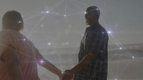 Mature man and senior woman holding hands on beach, showing tech network overlay connecting nodes. Connection, technology, connectivity, unity, resilience, senior, harmony - Powered by Shutterstock - Get 15% off with code: PIKWIZARD15