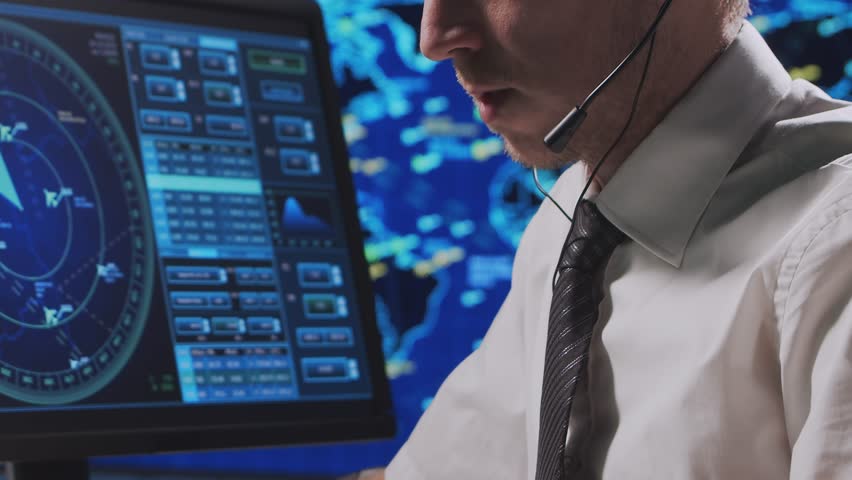 Professional air traffic controller in the control tower. Aircraft control officer works using radar, computer navigation and digital maps. Close-up portrait.