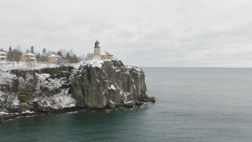 Split Rock Lighthouse On Icy Cliff And Snowy Shore Of Lake Superior In Two Harbors, Minnesota. drone approach