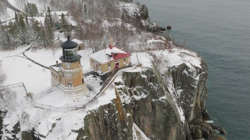 Split Rock Lighthouse On Icy Cliff On The North Shore Of Lake Superior In Minnesota, USA. aerial descending shot