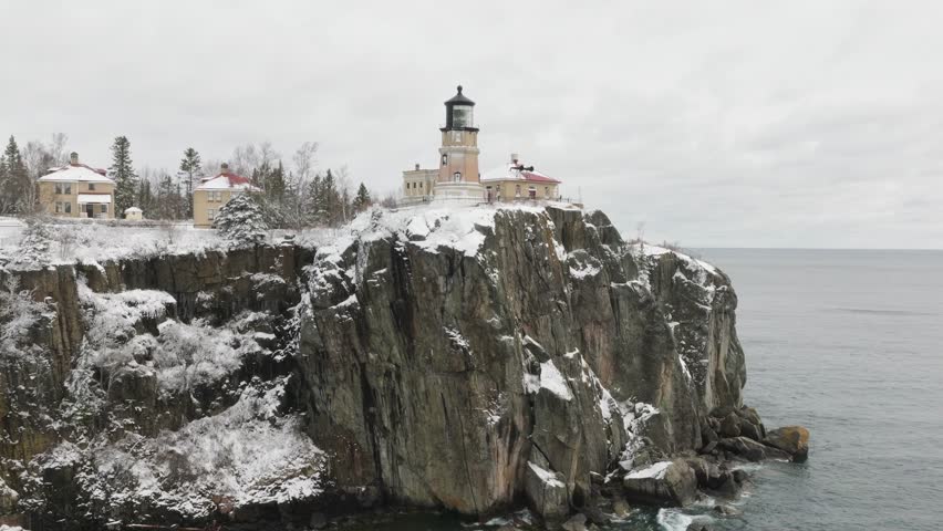 Split Rock Lighthouse And Keepers Home On The Rocky Cliff In Winter At Minnesota, USA. - aerial shot