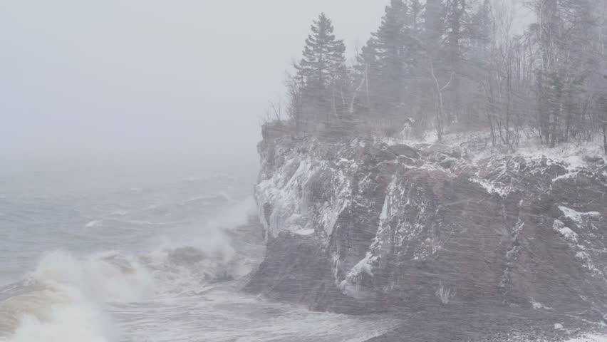 Waves Crashing On Snowy Cliff With Dense Fog And Blizzard On Rugged Shore Of Lake Superior In Minnesota. static shot