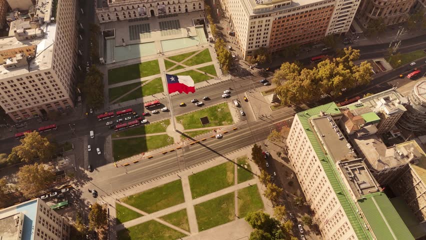 Traffic on main street of de Chile with waving flag during sunny day. Aerial top down shot. Patriotism and proud country in South America.