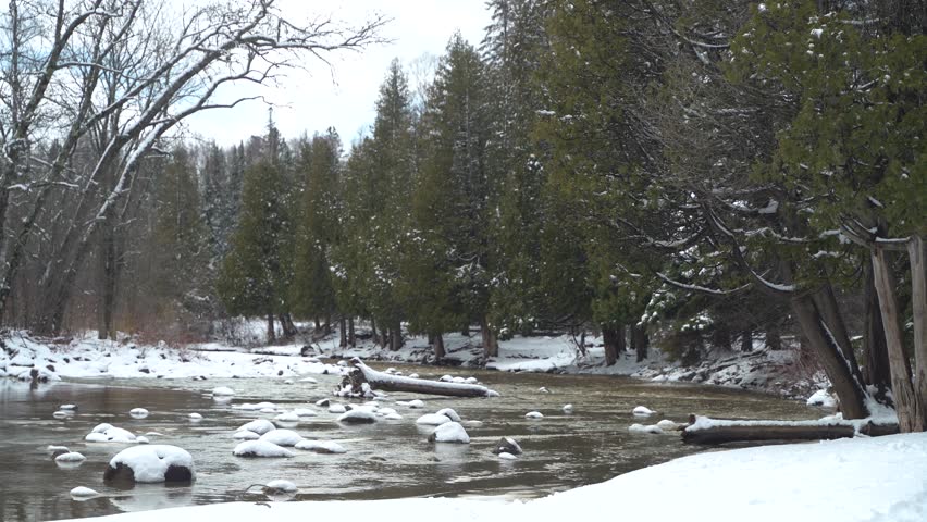 Scenic View Of Gooseberry River Flowing Into Lake Superior With Snow Falling In Winter. wide shot