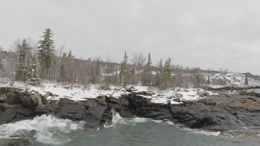 Winter Scenery On The North Shore Of Lake Superior. Snowy Cottages And Lodgings On Forested Landscape In Beaver Bay, Minnesota. wide drone shot