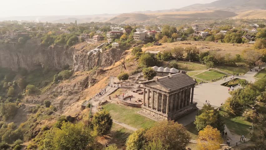 Aerial panning view visitors by The Garni Temple - classical colonnaded structure in the village of Garni. Pagan temple.Symbol of pre-Christian Armenia.Ancient greek roman style landmark