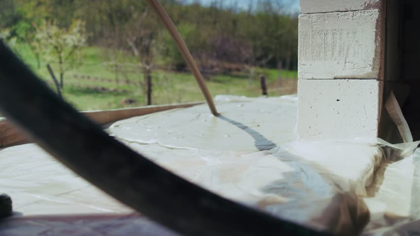 Workers pouring lightweight self-leveling concrete screed on a construction site
