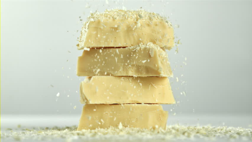Shredded white chocolate falls on a tower of chocolate pieces. Filmed on a high-speed camera at 1000 fps. High quality FullHD footage
