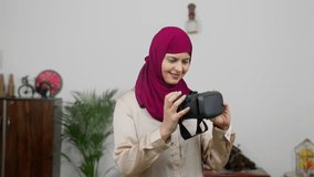 Muslim Woman in Hijab Scarf Looking at VR Headset and Adjusting it, Virtual Reality - Powered by Shutterstock - Get 15% off with code: PIKWIZARD15