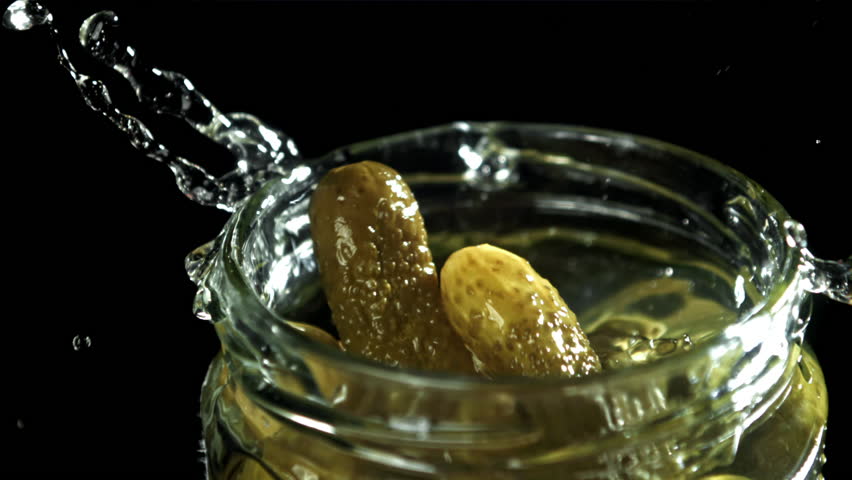 Pickled cucumbers fall into a jar of brine. Filmed on a high-speed camera at 1000 fps. High quality FullHD footage