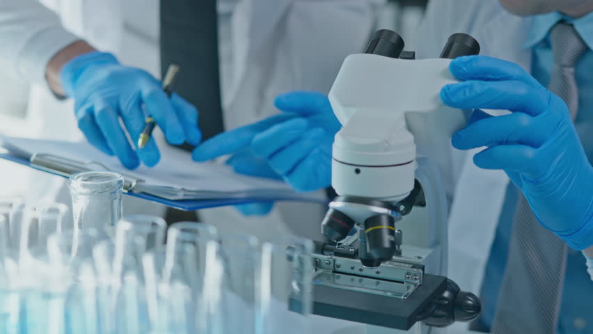 Scientist use and adjust looking to microscope cells and bacteria in laboratory for research on pharmacy medical for healing and antibody for protect disease and virus