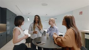 In a stylish and modern office environment, diverse group of ambitious businesswomen are engaged in a friendly and productive conversation during coffee break sharing ideas and collaborating - Powered by Shutterstock - Get 15% off with code: PIKWIZARD15