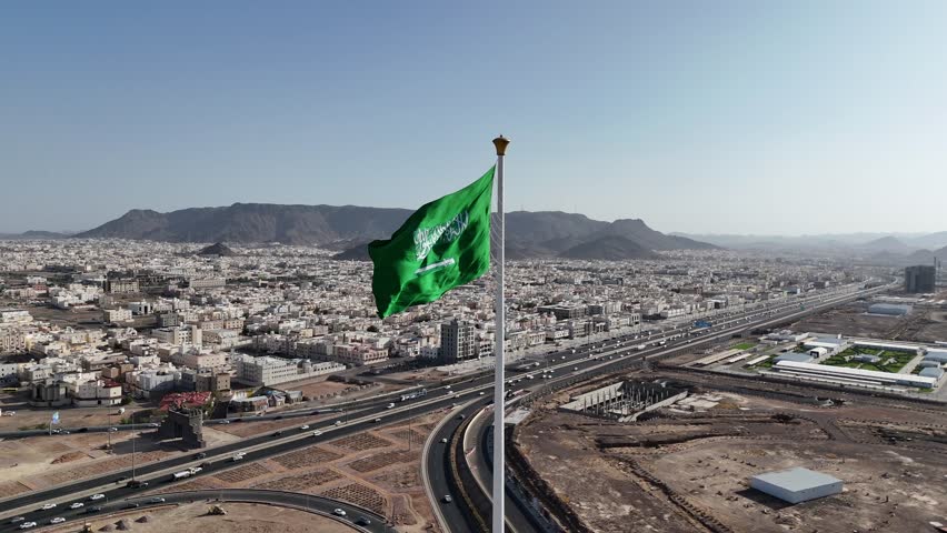 Saudi Arabia flag waving in the sky - Saudi national day and Founding Day - Drone 4k Video - aerial view 