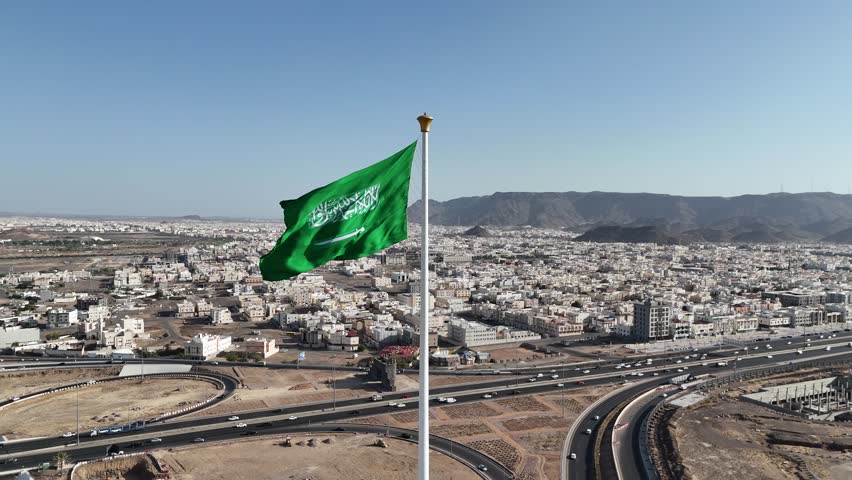 Saudi Arabia flag waving in the sky - Saudi national day and Founding Day - Drone 4k Video - aerial view 