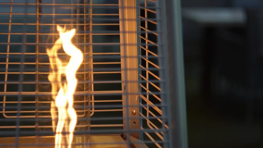 Dynamic closeup of dancing flames in outdoor heater grate