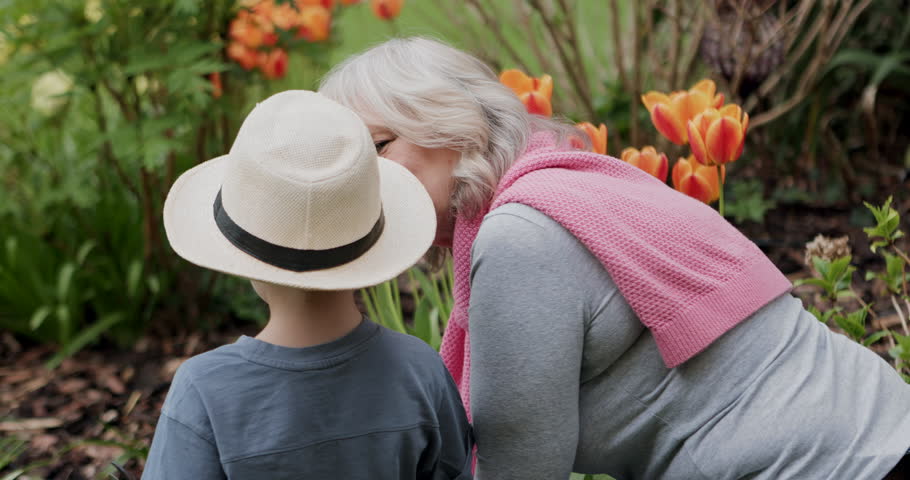 Gardening, flowers and grandma with child in backyard for learning nature skills, bonding and quality time. Family, love and happy grandmother and boy with tulips for landscaping, planting and spring