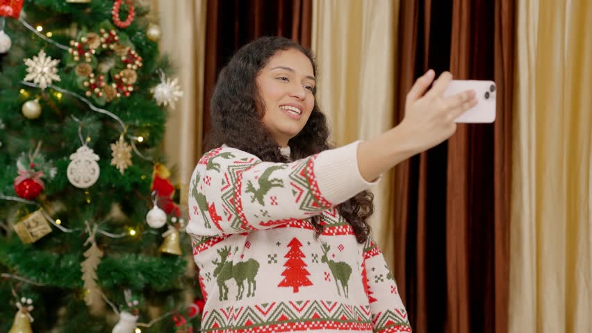 Happy Indian Woman Vlogging on Christmas with Christmas Tree in background