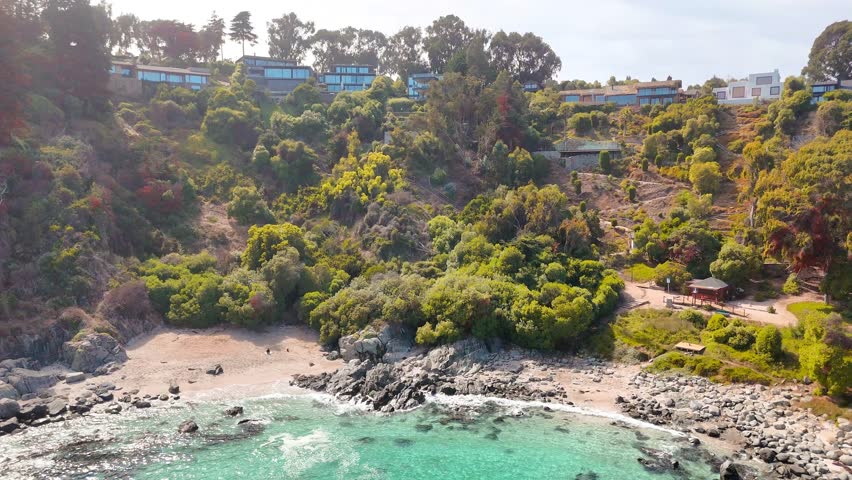 Aerial View of Playa Las Cujas with Turquoise Waters and Coastal Homes in Cachagua, Chile