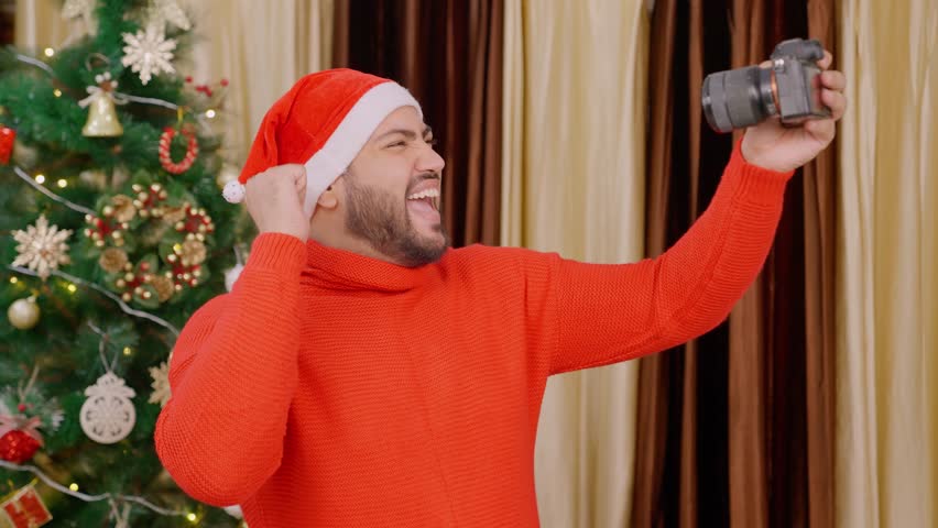 Indian Man Vlogging with Camera on Christmas with Christmas Tree in background