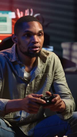Vertical Video African american angry player being frustrated about his lost competition, losing the video games online tournament in his living room. Mad irritated person with a gaming failure