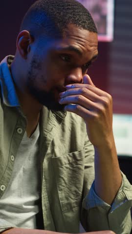 Vertical Video African american person receiving some bad news while doing remote work tasks, feeling overworked and under pressure to complete all his assignments. Young adult deals with burnout