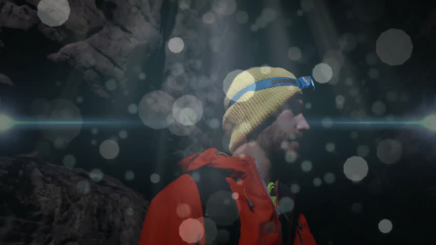 Mountaineer adjusting headlamp inside cave, showing dust particles with animated tech overlays. Adventure, exploration, rugged, outdoor, atmospheric, determination, solitude