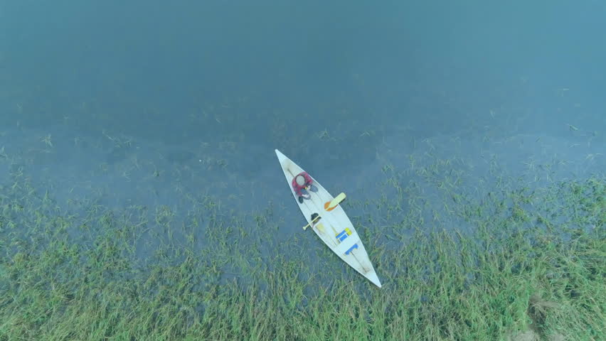 Man paddling canoe through marshland, showcasing floating chat icons and map pins in business tech. Nature, navigation, digital, communication, environmental, adventure, technology