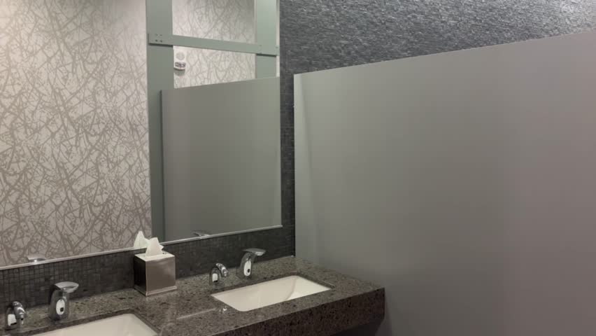 Camera pans across modern public bathroom