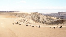 A group of people on ATVs explores a rugged desert, highlighting the expansive terrain and adventurous spirit. - Powered by Shutterstock - Get 15% off with code: PIKWIZARD15