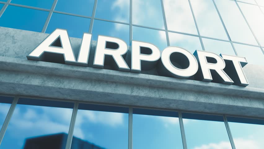 A slow pan across generic signage above the entrance to a modern generic airport building made of exposed concrete and reflective glass in the day time