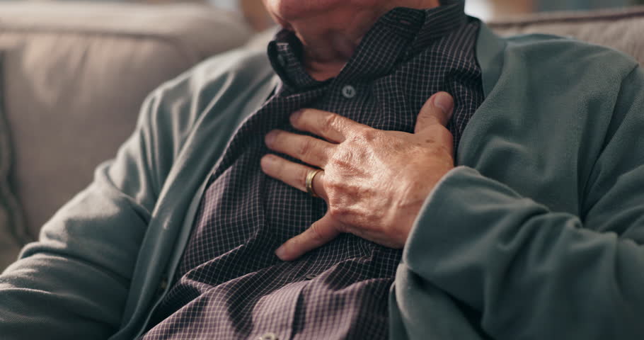 Sofa, old man and hands on chest for pain, cardiac symptoms and heart attack signs in retirement. Home, senior person and discomfort with respiratory illness, viral infection or tuberculosis on couch
