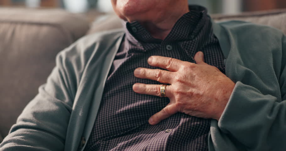 Sofa, old man and hands on chest for pain, cardiac symptoms and heart attack signs in retirement. Home, senior person and discomfort with respiratory illness, viral infection or tuberculosis on couch