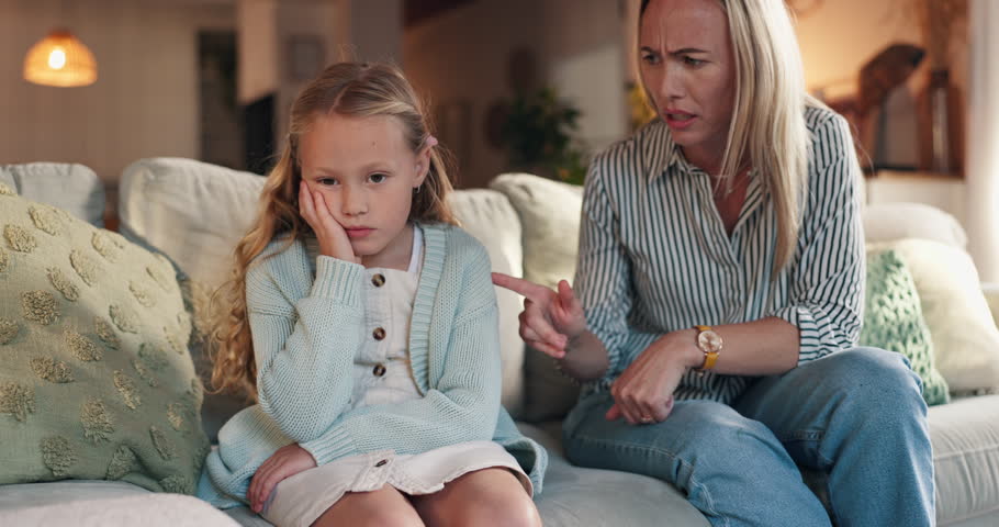 Discipline, mother and lecture child on sofa for bad behavior, attitude problem and punishment for tantrum. Angry woman, conflict and reprimand girl kid in home with fight, teaching manners or advice