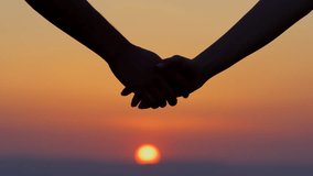 A couple holds hands during a sunset. - Powered by Shutterstock - Get 15% off with code: PIKWIZARD15