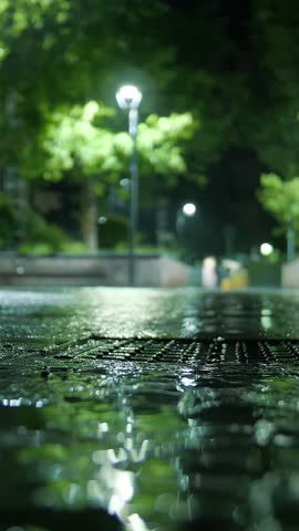Rain in the city. Submerged road. Night. Raindrops.