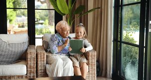 Grandmother, happy kid and tablet in home for learning, storytelling and play game online. Grandparent, child and girl with technology in living room for education, entertainment or talking together - Powered by Shutterstock - Get 15% off with code: PIKWIZARD15