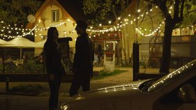 A couple enjoys a romantic night out under twinkling lights. - Powered by Shutterstock - Get 15% off with code: PIKWIZARD15