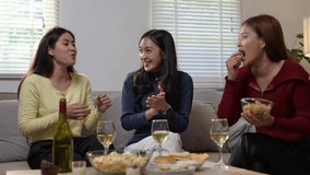 Three women are sitting on a couch, eating and drinking. They are laughing and enjoying each other's company - Powered by Shutterstock - Get 15% off with code: PIKWIZARD15