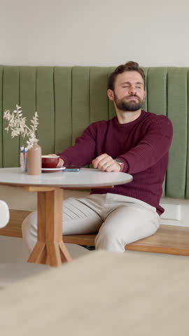 Man, phone and check time at cafe for business meeting, appointment or waiting for client with worry. Person, freelance consultant and smartphone app for schedule, impatient or thinking in restaurant