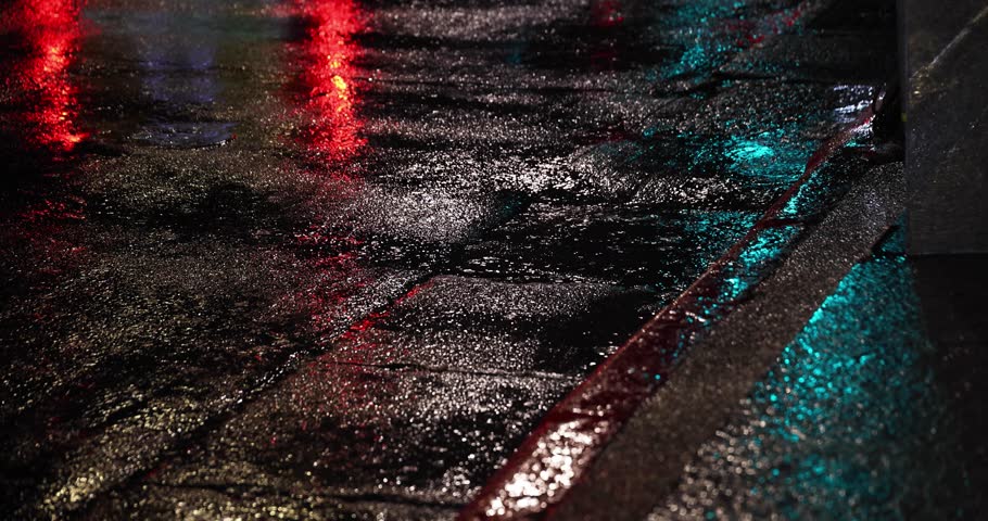 A slow motion of raindrop on the city street at night
